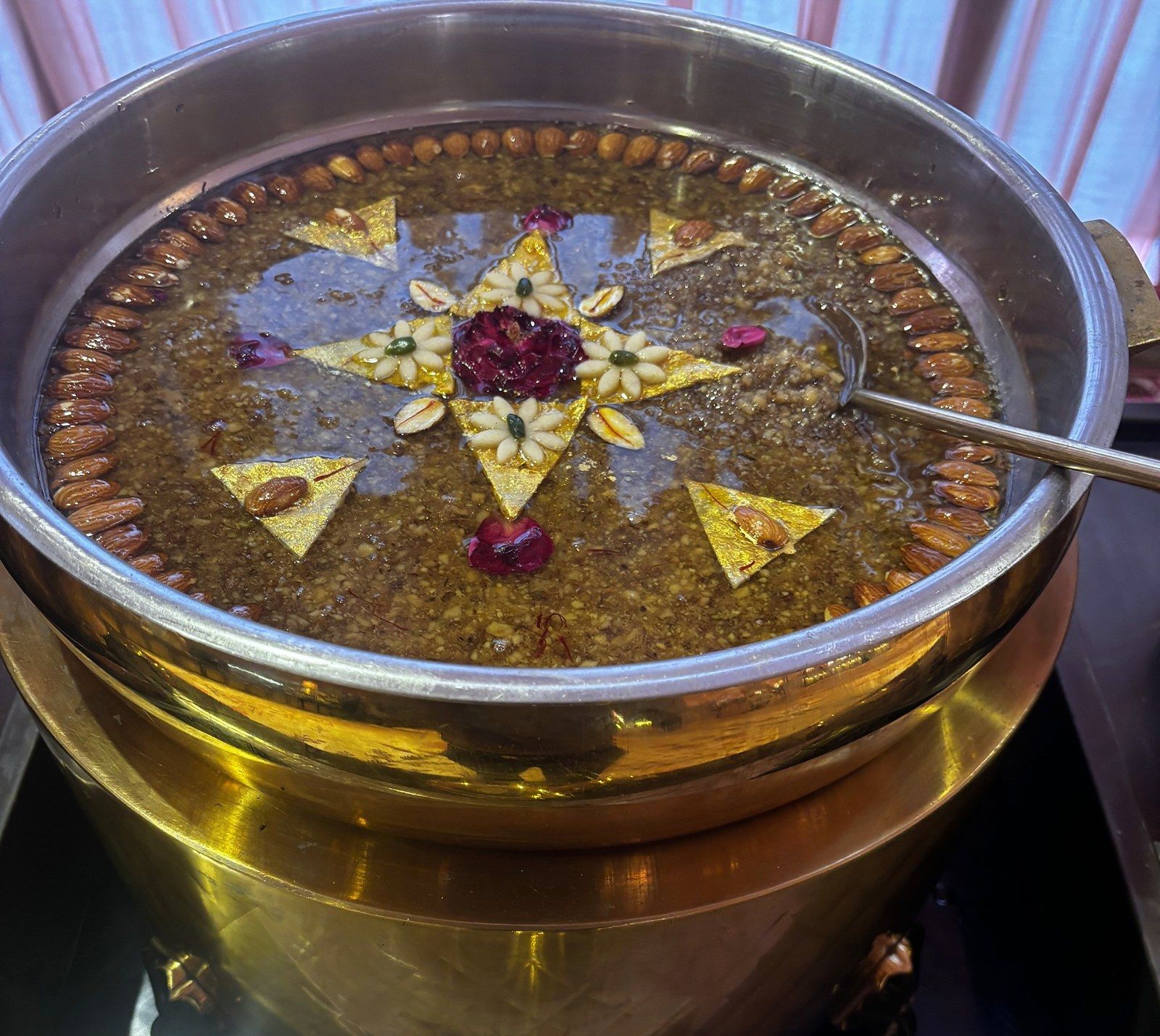 Akhrot ka halwa under gold leaf in a brass handi
