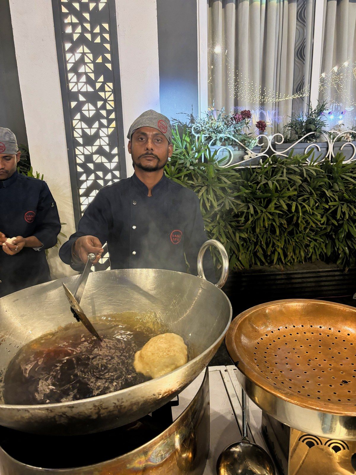 A chef lifting puris from the kadhai